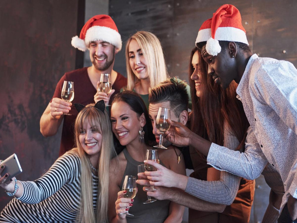 Group of friends celebrating at a Christmas party with drinks, showing how festive alcohol consumption can affect sleep