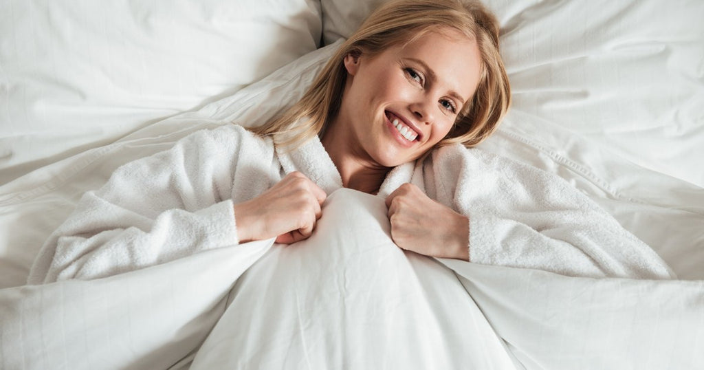 Happy woman relaxing in bed after a good night’s sleep – The Sleep Shop Athlone Ireland